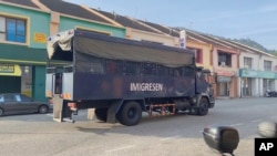 In this image taken from a video, an immigration truck with unidentified people onboard is driven on a road that leads to Lumut Naval Base Tuesday, Feb. 23, 2021 in Lumut, Malaysia.