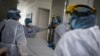 Médicos y enfermeras parados frente a la entrada de la Unidad de Cuidados Intensivos (UCI) para pacientes que padecen la enfermedad por coronavirus (COVID-19) en el hospital El Tunal en Bogotá, Colombia, 12 de junio de 2020.
