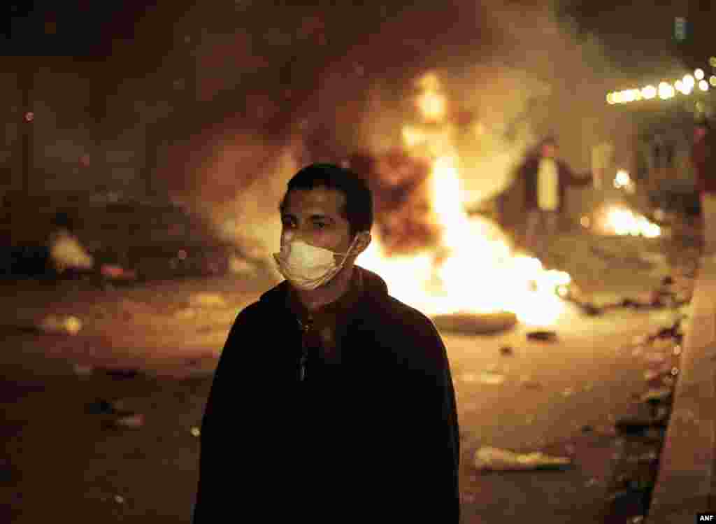 An anti-government protester is backdropped by a fire set up by protesters near the Tahrir Square Jan. 28, 2011.