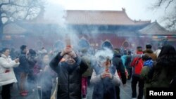 Warga China membakar dupa dan berdoa untuk keberuntungan di Kuil Yonghegong Lama pada hari pertama tahun baru ayam jantan di Beijing, Cina, 28 Januari 2017. (REUTERS/Damir Sagolj).