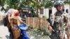 Dua perempuan melintas di depan aparat keamanan di Poso. (Foto: Yoanes Litha/ dok) 