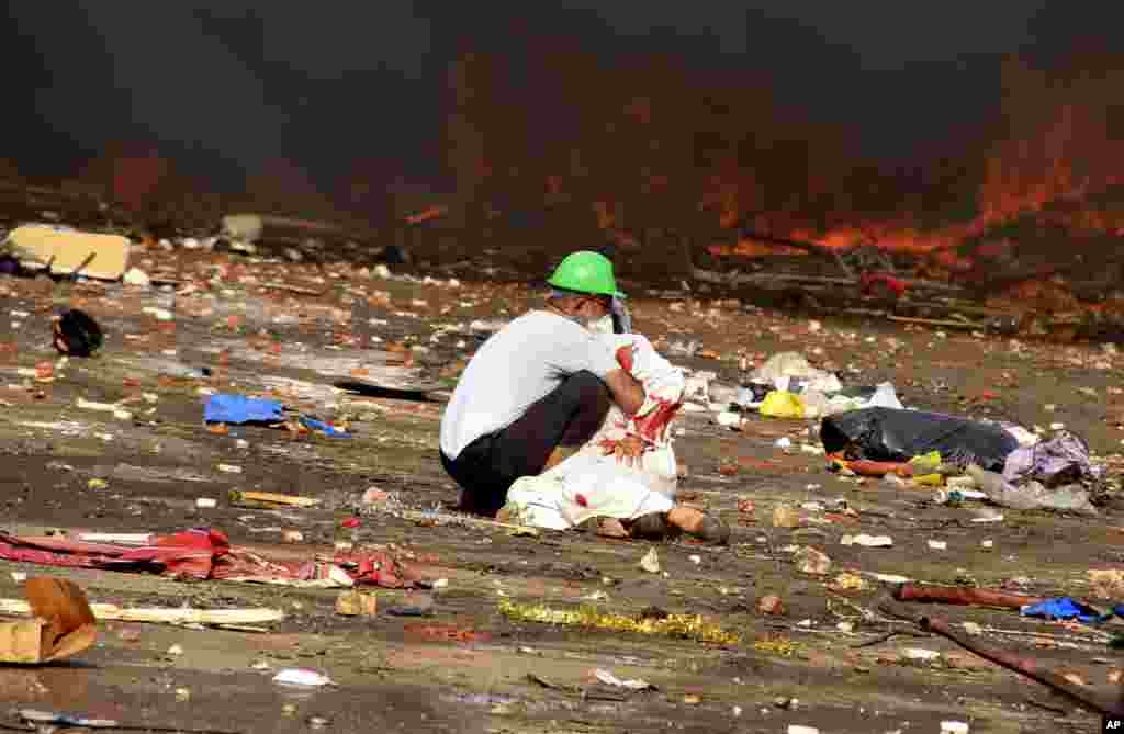 A protester comforts a wounded colleague after Egyptian security forces began to clear a sit-in by supporters of ousted President Mohamed Morsi in the eastern Nasr City district of Cairo, Egypt, Aug. 14, 2013.