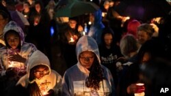 People hold candles during a vigil for the centennial commemorations of the Tulsa Race Massacre in the historic Greenwood neighborhood, May 31, 2021, in Tulsa, Okla.