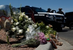 Flowers adorn a makeshift memorial near the scene of a mass shooting at a shopping complex in El Paso, Texas, Aug. 4, 2019.