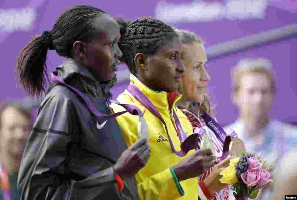 Ethiopia's gold medal winner Tiki Gelana, right, Kenya's silver medal winner Priscah Jeptoo, left, and Russia's bronze medalist Tatyana Petrova Arkhipova during the ceremony for the women's marathon at 2012 Summer Olympics, August 5, 2012.