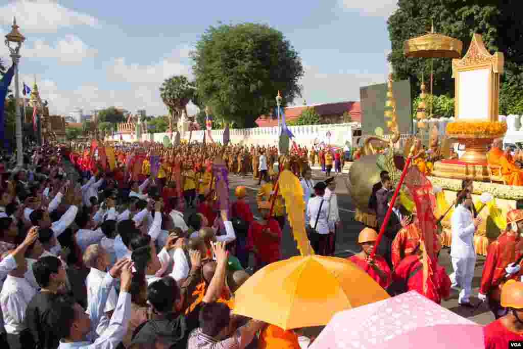 ប្រជាជនកម្ពុជាដែលចូលរួមក្នុងព្រះរាជពិធីដង្ហែព្រះរាជគោរមងារកិត្តិយស "ព្រះស្រីលោកធម្មិករាជ" ថ្វាយព្រះមហាក្សត្រសម្ដេចព្រះបរមនាថ នរោត្ដម សីហមុនី ព្យាយាមថតរូបព្រះទីនាំង នាព្រឹកថ្ងៃទី៣ មិថុនា ២០១៥ នៅមុខព្រះបរមរាជវាំង។