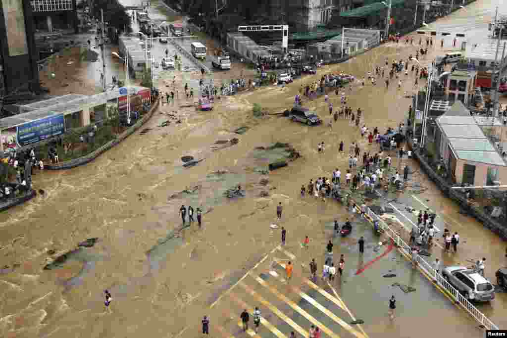 Vehicles come to a standstill at a flooded crossroad in Pingba, Guizhou province, China.
