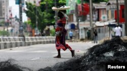 Seorang wanita berjalan melewati sisa-sisa barikade di daerah Surulere di Lagos, Nigeria 23 Oktober 2020. (Foto: REUTERS/Afolabi Sotunde)