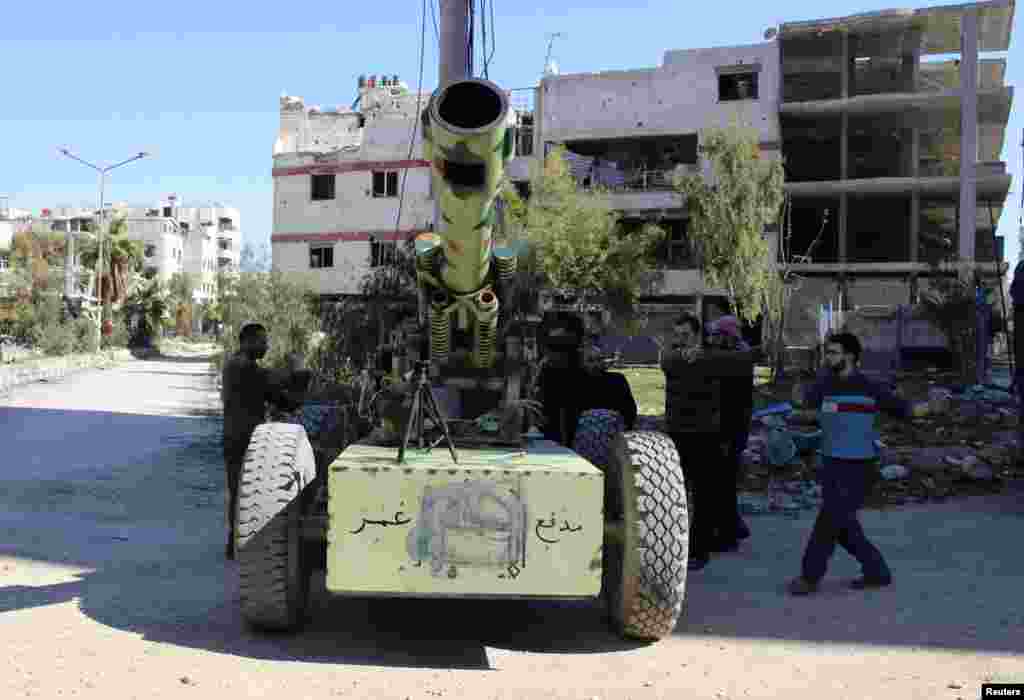 Free Syrian Army fighters prepare to fire an artillery cannon towards forces loyal to Syria's President Bashar al-Assad in the eastern Damascus suburb of Ghouta, March 23, 2014.