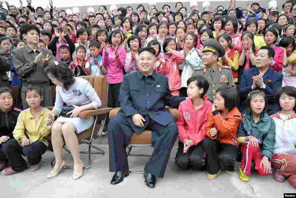 Pemimpin Korea Utara Kim Jong-un (tengah) dan isterinya Ri Sol-ju saat berkunjung ke kamp anak-anak 'Pyongyang Myohyangsan' yang terletak di kaki Gunung Myohyang di Provinsi Phyongan Utara (foto courtesy: KCNA).