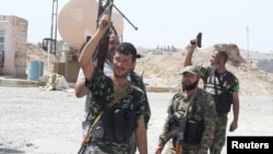 FILE - Shii'te volunteers carry their weapons during an intensive security deployment to fight against militants of the Islamic State, in Tuz Khurmatu, Iraq, Aug. 31, 2014. The Iraqi army and the Shi'ite Popular Mobilization Forces on Feb. 7, 2018, began cracking down on remaining IS fighters regrouping in Tuz Khurmatu.