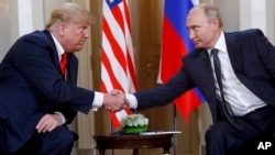 FILE - U.S. President Donald Trump and Russian President Vladimir Putin shake hands at the beginning of a bilateral meeting at the Presidential Palace in Helsinki, Finland, July 16, 2018.