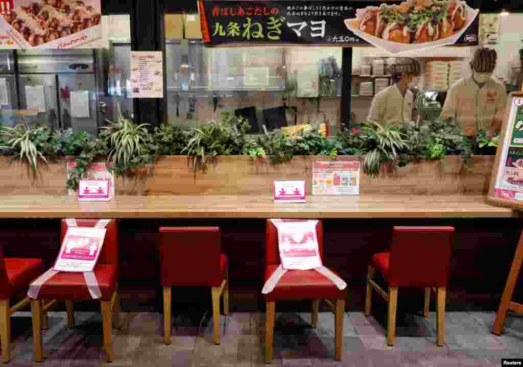 Social distancing signs are place on a table and chairs at a restaurant in Japan's supermarket group Aeon's shopping mall as the mall reopens amid the coronavirus disease (COVID-19) outbreak in Chiba, Japan May 28, 2020. REUTERS/Kim Kyung-Hoon