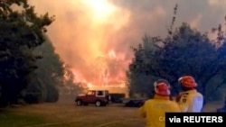 FILE PHOTO: Firefighters work at the scene of a bushfires in Bilpin, New South Wales, Australia in this still image from a social media video December 15, 2019. Andrew Mitchell/Cottage Point Rural Fire Brigade via REUTERS ATTENTION EDITORS - THIS…