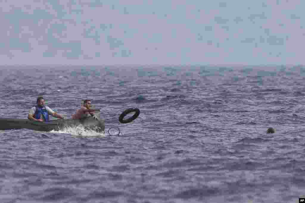 A Greek fisherman rescues a Syrian migrant, right, after his boat stalled while crossing from Turkey to the island of Lesbos, Greece, Sept. 22, 2015. More than 260,000 asylum-seekers have arrived in Greece so far this year, most reaching the country's eastern islands on flimsy rafts or boats from the nearby Turkish coast.