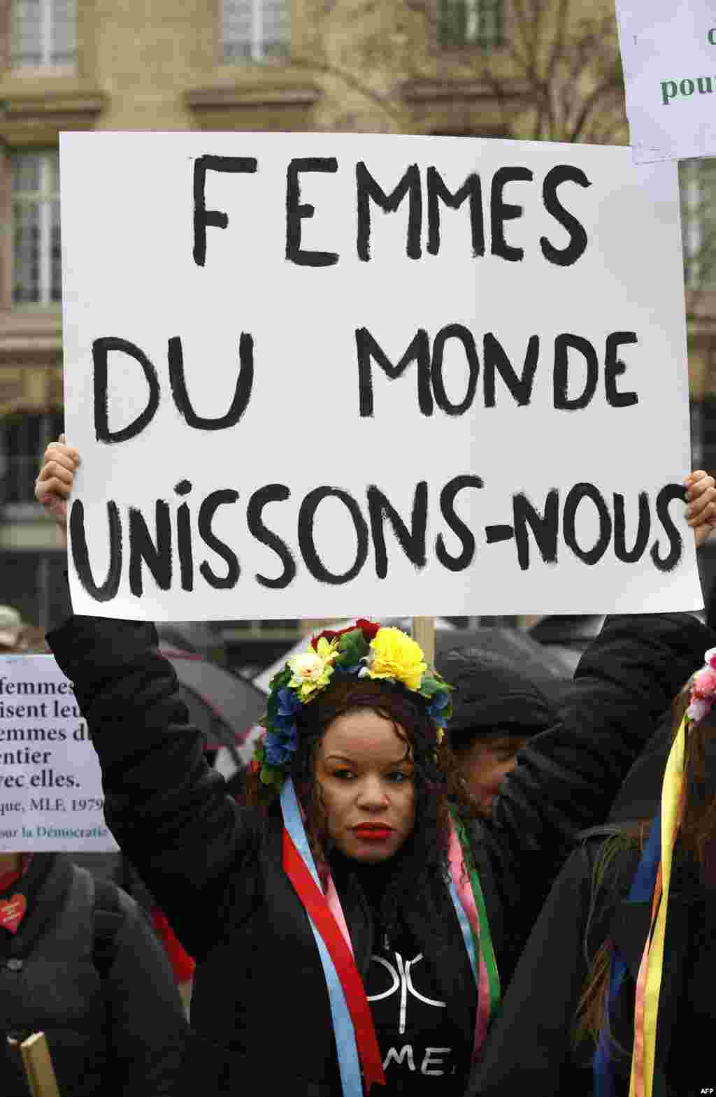 Une Femen tient une pancarte "Les femmes du monde s'unissent" sur la place de la République, lors de la Journée internationale des droits des femmes, à Paris, le 8 mars 2018.
