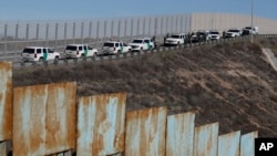 Kendaraan milik Patroli Perbatasan AS diparkir di sepanjang pagar sekunder saat mereka merespon kepada kelompok migran Amerika Tengah yang melintasi perbatasan secara ilegal, Tijuana, Meksiko, Minggu, 9 Desember 2018 (foto: AP Photo/Rebeca Blackwell)