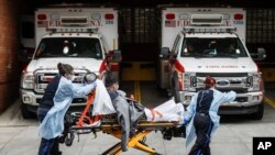 Patients are brought into Wyckoff Heights Medical Center by staff wearing personal protective gear due to COVID-19 concerns, Tuesday, April 7, 2020, in the Brooklyn borough of New York. 