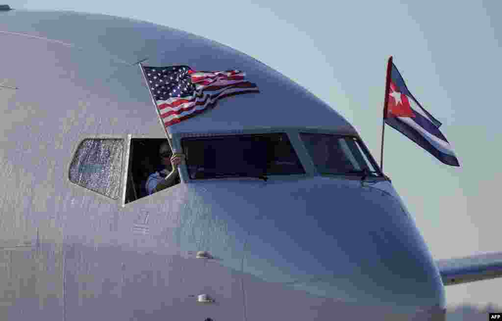 An American Airlines plane fluttering US and Cuba national flags is seen uppon arrival at Jose Marti International Airport becoming the first Miami-Havana commercial flight in 50 years, coinciding with the beginning of the tributes to late Cuban leader Fidel Castro in Havana.