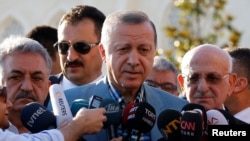 FILE - Turkey's President Tayyip Erdogan talks to media after the Eid al-Fitr prayers in Istanbul, June 25, 2017.