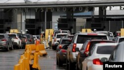 Cars line up to cross into the U.S. at the Mexico-U.S. San Ysidro border crossing, in Tijuana, Mexico, March 19, 2020.