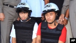 Buruh dari Myanmar, Saw, (kiri) dan Win didampingi petugas polisi dalam konferensi pers di Koh Tao, Surat Thani, Thailand, (3/10/2014). Mereka mengaku sebagai pelaku pembunuhan 2 turis Inggris di Thailand. 