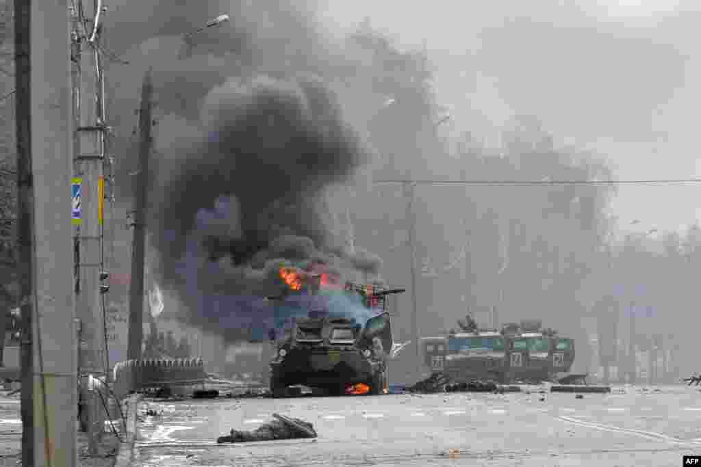 A Russian Armored personnel carrier (APC) burns next to unidentified soldier's body during a fighting with the Ukrainian armed forces in Kharkiv.