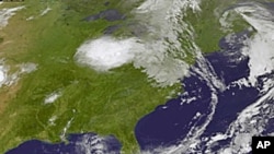 This image provided by NASA taken at 2:32 a.m. EDT Wednesday morning Aug. 3, 2011 shows tropical storm Emily, lower right. Forecasters at the National Hurricane Center in Miami said up to 10 inches (25 centimeters) of rain could fall Wednesday in some par