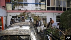Avganistanci ispred kuće porodice Ahmadi oštećene u američkom udaru dronom u Kabulu, 29. avgusta 2021. 