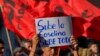 Un manifestante sostiene un cartel durante una protesta antigubernamental contra el aumento de los precios del combustible, en Quito, Ecuador, el 12 de junio de 2024.