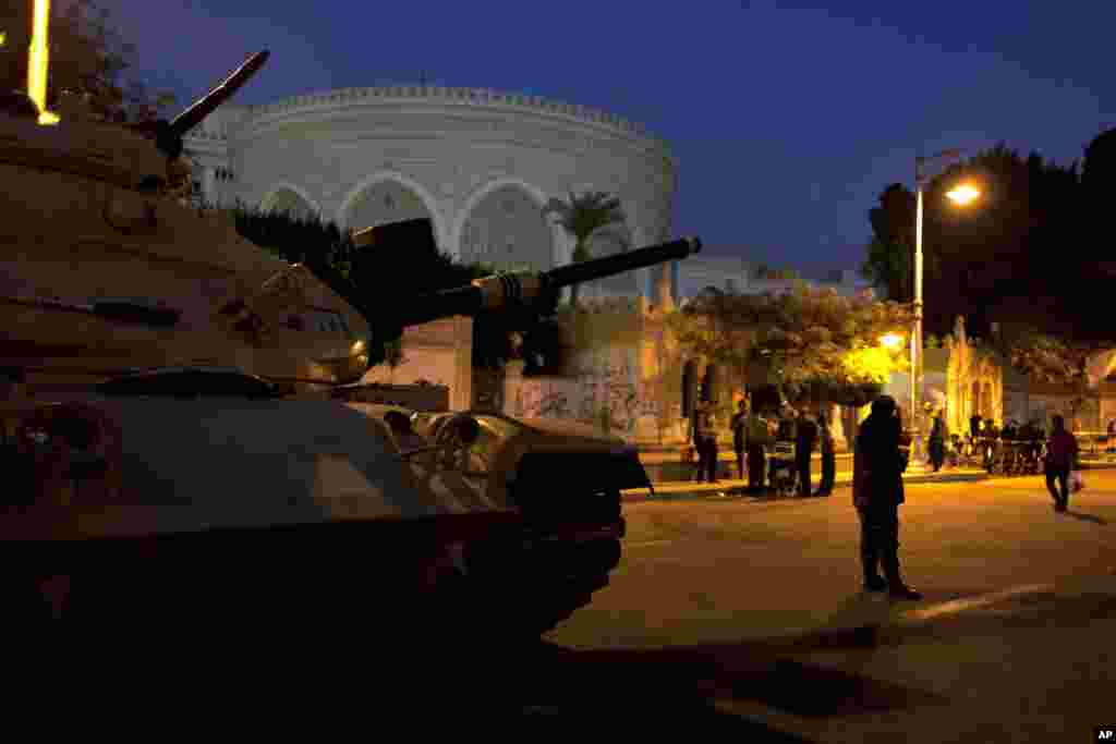 An army soldier guards his tank in front the presidential palace in Cairo, Egypt, December 12, 2012.
