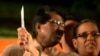 Seorang perempuan India memegang pisau sambil berfoto dalam acara yang diselenggarakan oleh partai nasionalis Hindu India, Partai Shiv Sena, di Mumbai, 23 Januari 2013. Shiv Sena memberikan pisau sebagai alat bela diri sebagai hadiah ulang tahun mendiang pendirinya Bal Thackeray.
