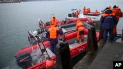 FILE - Ministry of Emergency Situations employees prepare rescue boats at a pier just outside Sochi, Russia, Dec. 26, 2016. 