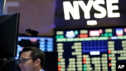FILE - Traders work on the floor at the New York Stock Exchange in New York, July 8, 2015.