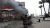 A protester part of the Black Bloc, holds the Egyptian national flag during clashes with riot police near Tahrir Square, Cairo, Egypt, Jan. 28, 2013.