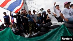 Para demonstran anti-pemerintah di Bangkok mengkonfrontasi polisi anti-huru hara Thailand (14/2). (Reuters/Damir Sagolj)