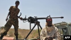 Somali government soldiers looking out from a machine gun mounted pick-up truck at Tobanka Buundo in the lower Shabelle region, near the Somalian capital Mogadishu, where residents created a road block during a protest against the Islamist Al-Shabab insur