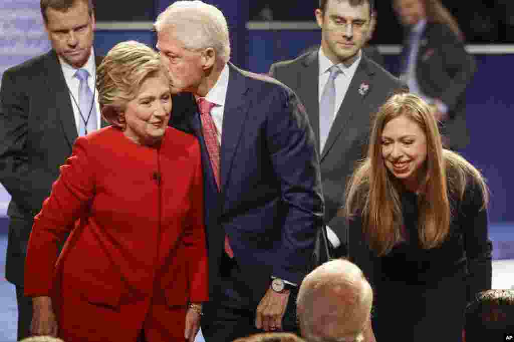 Former President Bill Clinton kisses Democratic presidential nominee Hillary Clinton as she and their daughter, Chelsea Clinton, greet supports during the presidential debate at Hofstra University in Hempstead, N.Y., Sept. 26, 2016.