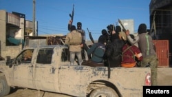 FILE - Masked Sunni gunmen, likely belonging to the group Islamic State of Iraq and the Levant (ISIL), are seen in the city of Falluja Feb. 8, 2014.