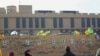Foto-foto kombatan Kataeb Hizbullah terpasang di dinding gedung Kedutaan Besar AS di Baghdad, Ibu Kota Irak, 1 Januari 2020. (Foto: AFP)