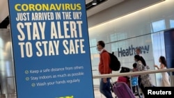 Des passagers de vols internationaux arrivent à l'aéroport de Heathrow, Londres, Grande-Bretagne, 29 juillet 2020.