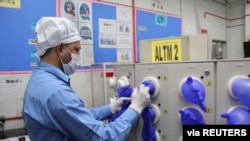 Seorang pekerja memeriksa sarung tangan karet yang baru diproduksi di pabrik Top Glove, Klang, Malaysia, 3 Maret 2020. (Top Gloves/Anas Zakwan/handout via Reuters).