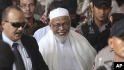 Ulama radikal Abu Bakar Baasyir (tengah) meninggalkan pengadilan setelah hakim menjatuhkan vonis di pengadilan Jakarta, 2011.