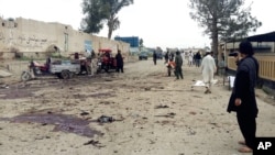 Afghan men inspect the site of a suicide attack in Khost city, Afghanistan, April 2, 2015. 