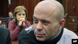 Politkovskaya's daughter Vera, background, looks at former police officer Dmitry Pavlyuchenko, right, prior to the judge's verdict, at the Moscow City Court, Russia, December 14, 2012