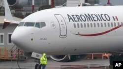 ARCHIVO - Un trabajador con una máscara pasa junto a un Boeing 737 Max 9 construido para Aeroméxico mientras lo preparan para un vuelo desde el Aeropuerto Municipal de Renton, en Renton, Washington, el 18 de noviembre de 2020. 