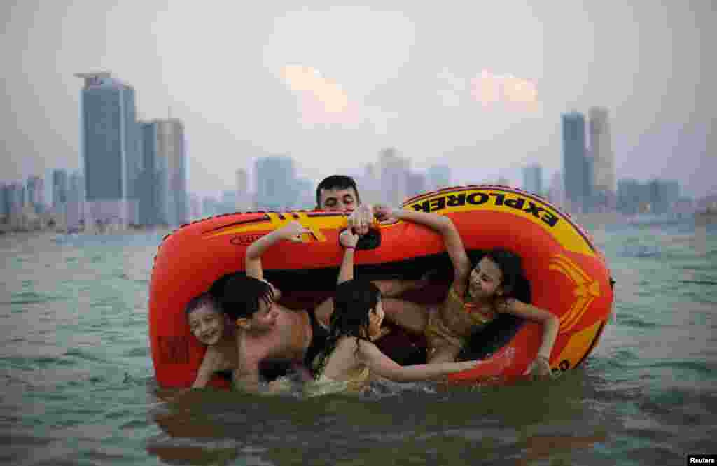 Seorang laki-laki bermain dengan keluarganya di Pantai Mamzar di Dubai, Uni Emirat Arab.