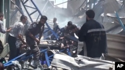 FILE - An image made from video posted online by the Shaam News Network, a loosely organized group opposed to Bashar Assad, shows rescuers taking a victim from the site of Syrian government airstrikes in Douma, a suburb of Damascus, Aug. 16, 2015. 