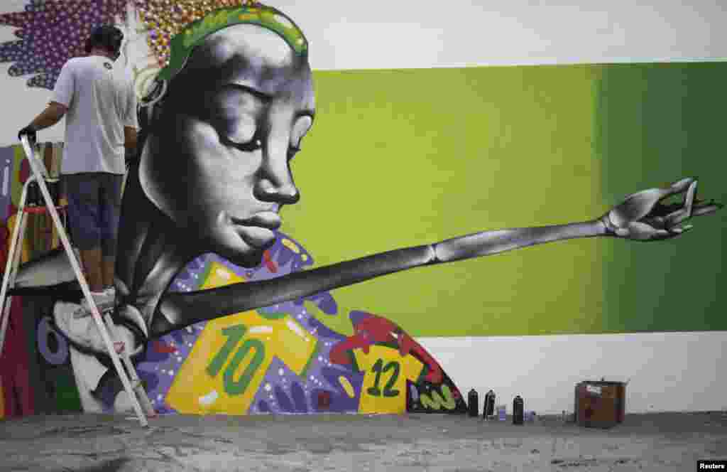 O grafiteiro Barba pinta um mural em honra do Mundial de Futebol, Rio de Janeiro, Maio 9, 2014.