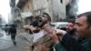 FILE - A father reacts after the death of two of his children, whom activists said were killed by shelling by forces loyal to Syria's President Bashar al-Assad, at al-Ansari area in Aleppo, Jan. 3, 2013. 